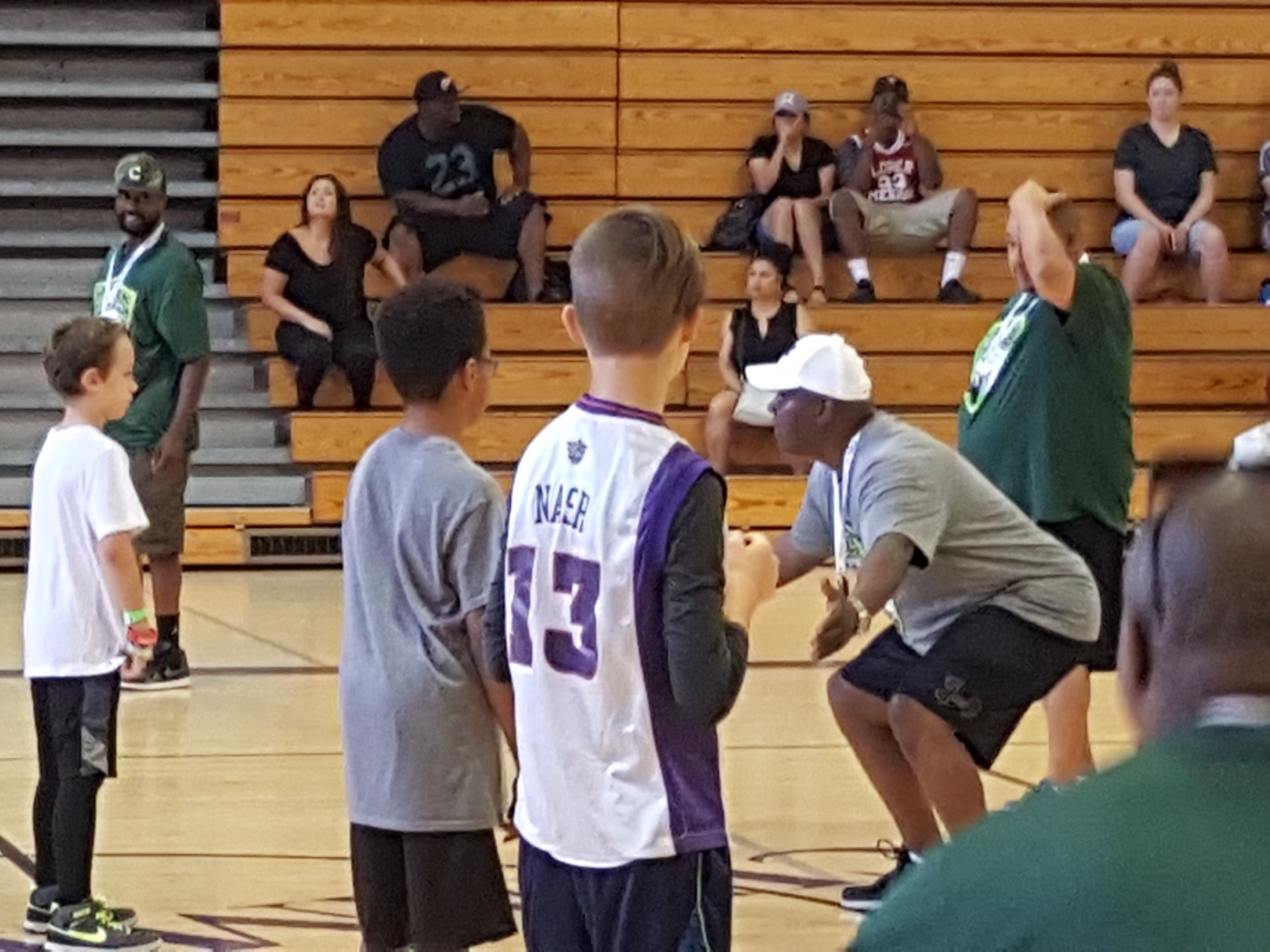 Coach crouching to talk with young players