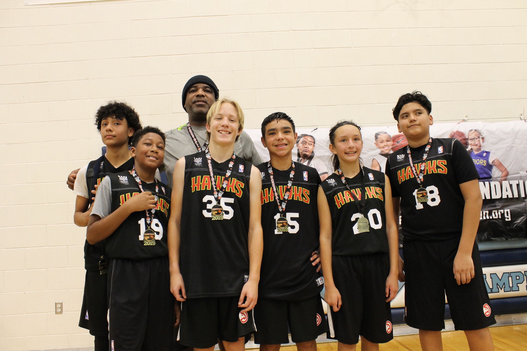Team celebrating with medals and their coach