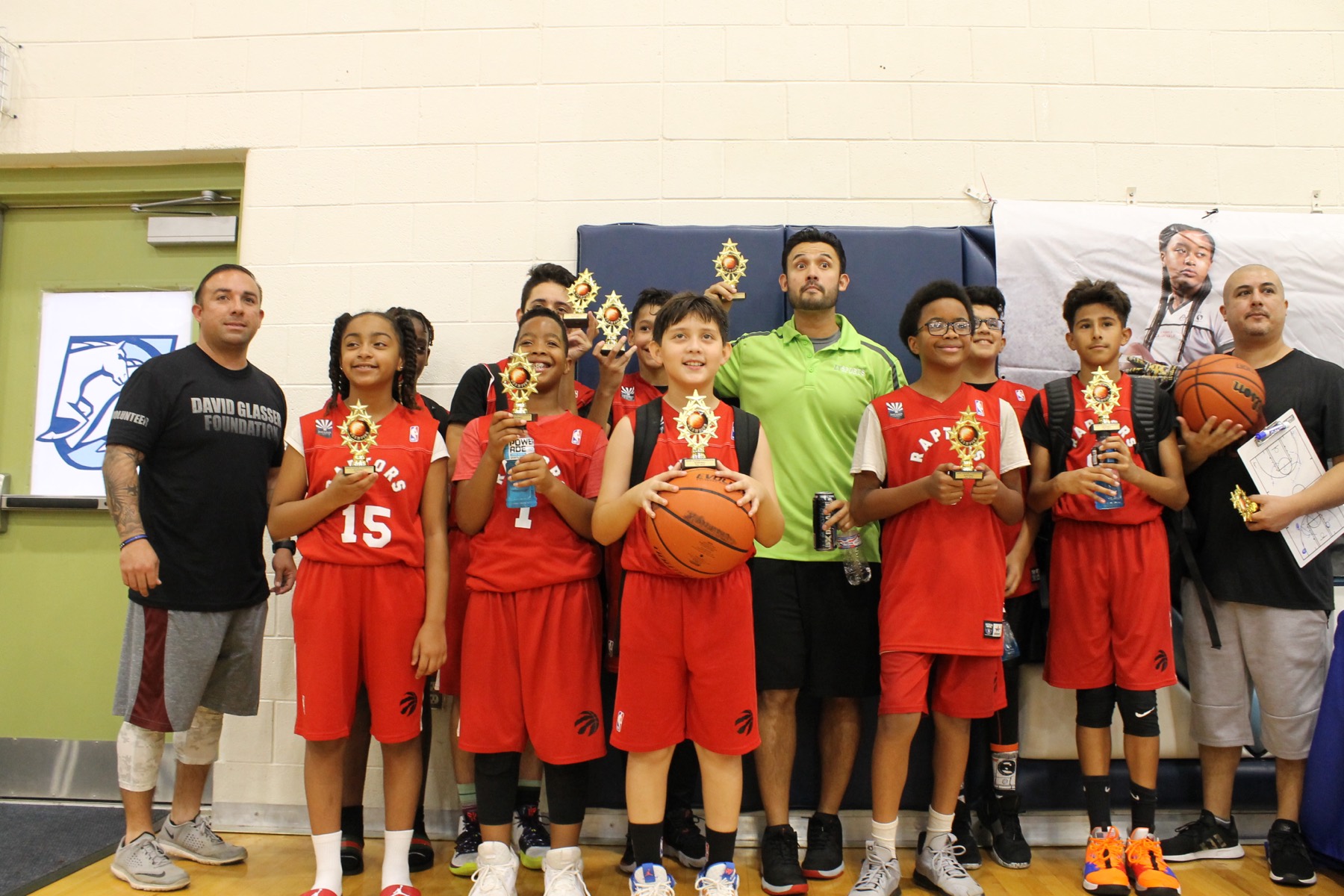 Team holding trophies with coaches
